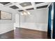 Formal dining area features coffered ceilings, wainscoting, hardwood floors, and a contemporary chandelier at 3975 Silverthorn Trce, Cumming, GA 30028