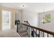 Upstairs hallway with railing leading to bedrooms and a view of natural light from the windows at 3975 Silverthorn Trce, Cumming, GA 30028