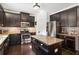 Well-appointed kitchen with dark cabinets, granite countertops, stainless steel appliances, and an island at 3975 Silverthorn Trce, Cumming, GA 30028