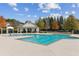 Community swimming pool with a clubhouse, lounge chairs, and well-maintained landscaping at 3975 Silverthorn Trce, Cumming, GA 30028