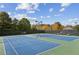 Two blue tennis courts with lights and benches provide a recreational amenity at 3975 Silverthorn Trce, Cumming, GA 30028