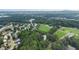 Aerial view showcases a neighborhood with mature trees, green fields, and homes with manicured lawns at 5809 Warren Farm Sw Rd, Powder Springs, GA 30127