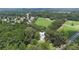 Aerial view of a home surrounded by mature trees and open fields in a wooded residential area at 5809 Warren Farm Sw Rd, Powder Springs, GA 30127