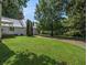 Large backyard with a well-kept lawn, mature trees, and a detached garage at 5809 Warren Farm Sw Rd, Powder Springs, GA 30127