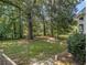 Fenced-in backyard with mature trees and a mix of grass and natural ground cover at 5809 Warren Farm Sw Rd, Powder Springs, GA 30127