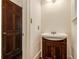 Cozy powder room featuring a dark wooden vanity, complete with a sleek white sink and silver fixtures at 5809 Warren Farm Sw Rd, Powder Springs, GA 30127