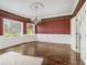 Dining room featuring hardwood floors, wainscoting, two bright windows, and striped wallpaper at 5809 Warren Farm Sw Rd, Powder Springs, GA 30127