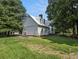 Rear exterior view with a fenced-in yard, mature trees, and concrete patio at 5809 Warren Farm Sw Rd, Powder Springs, GA 30127