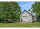 Exterior side view of home with a patio and tree-filled yard at 5809 Warren Farm Sw Rd, Powder Springs, GA 30127