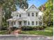 Charming two-story white home with a metal roof, front porch, brick walkway and mature landscaping at 5809 Warren Farm Sw Rd, Powder Springs, GA 30127