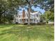 Charming white two-story home with a metal roof, covered porch, mature trees, and large front yard at 5809 Warren Farm Sw Rd, Powder Springs, GA 30127