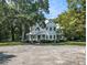 Charming two-story home featuring a metal roof, covered porch, and lush landscaping at 5809 Warren Farm Sw Rd, Powder Springs, GA 30127