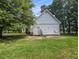 Back exterior with concrete patio, mature trees, and a fenced yard at 5809 Warren Farm Sw Rd, Powder Springs, GA 30127