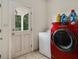 Laundry room with red front load washer and dryer, laundry sink, and tile floors at 5809 Warren Farm Sw Rd, Powder Springs, GA 30127