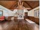 Grand living room featuring wooden beams, unique wood walls and hardwood floors, complete with stone fireplace at 5809 Warren Farm Sw Rd, Powder Springs, GA 30127