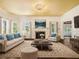 Staged living room features hardwood floors, neutral furniture, fireplace, and many windows offering natural light at 5809 Warren Farm Sw Rd, Powder Springs, GA 30127