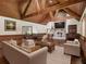 Staged living room featuring wooden beams, unique wood walls and hardwood floors, complete with stone fireplace at 5809 Warren Farm Sw Rd, Powder Springs, GA 30127