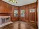 Living room with original wood paneling, fireplace, and decorative glass windowed front door at 5809 Warren Farm Sw Rd, Powder Springs, GA 30127