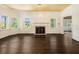 Empty living room featuring hardwood floors, a fireplace, detailed trim, and several large windows at 5809 Warren Farm Sw Rd, Powder Springs, GA 30127