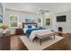 Staged main bedroom offering many windows for natural light, hardwood floors, and fireplace at 5809 Warren Farm Sw Rd, Powder Springs, GA 30127