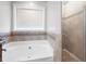 This bathroom boasts a soaking tub, a shower, and neutral tile at 3952 Rhyne Way, Smyrna, GA 30082