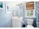 This blue bathroom has a white vanity, a decorative mirror, and a patterned shower curtain at 3952 Rhyne Way, Smyrna, GA 30082