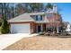Charming two-story home featuring a brick facade, attached garage, and beautifully landscaped front yard at 3952 Rhyne Way, Smyrna, GA 30082
