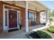 Inviting front porch with brick columns, a bench, and a stylish red door at 3952 Rhyne Way, Smyrna, GA 30082