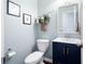 Charming powder room with stylish navy vanity, decorative mirror, and elegant fixtures at 3952 Rhyne Way, Smyrna, GA 30082