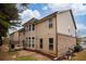 Backyard view of home with beige siding and brick foundation and patio with outdoor activities at 5825 Trailwood Ct, Suwanee, GA 30024