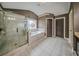 A spacious bathroom with a glass shower, soaking tub, and tiled floor at 5825 Trailwood Ct, Suwanee, GA 30024