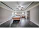 Bedroom featuring hardwood floors, a tray ceiling, and built-in wainscoting at 5825 Trailwood Ct, Suwanee, GA 30024