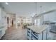 Spacious kitchen boasts stainless appliances, granite counters, and an island with bar seating and open access to the living room at 5825 Trailwood Ct, Suwanee, GA 30024