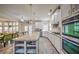 Bright open concept kitchen with stainless appliances, white cabinets, a functional island and an adjacent dining area at 5825 Trailwood Ct, Suwanee, GA 30024