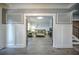 An entry to a cozy living room featuring paneled walls, light gray paint, and hardwood floors at 5825 Trailwood Ct, Suwanee, GA 30024