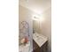 Powder room featuring neutral paint, vanity with sink, decorative mirror, and an ornate decorative lattice at 5989 Zane Ct, Douglasville, GA 30135