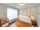 Cozy bedroom with a wood bed, neutral walls, wood-look floors, and a large window that provides natural light at 5989 Zane Ct, Douglasville, GA 30135
