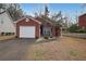 Charming brick home featuring an attached garage, a well-manicured lawn, and a welcoming red front door at 5989 Zane Ct, Douglasville, GA 30135