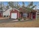 Charming brick home featuring an attached garage, a well-manicured lawn, and a welcoming red front door at 5989 Zane Ct, Douglasville, GA 30135