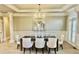 Formal dining room with elegant chandelier, wainscoting, and large arched windows at 2821 Grey Moss Pass, Duluth, GA 30097