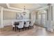 Formal dining room with elegant chandelier, wainscoting, and large arched windows at 2821 Grey Moss Pass, Duluth, GA 30097