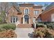 Elegant brick home entrance with stately columns, arched windows, and manicured landscaping at 2821 Grey Moss Pass, Duluth, GA 30097