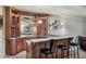 Basement wet bar features custom cabinetry, granite countertops, mirrored backsplash, and bar seating at 2821 Grey Moss Pass, Duluth, GA 30097