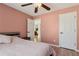 Bedroom with light pink walls, wood floors and ceiling fan at 2882 Manor Glen Ln, Suwanee, GA 30024