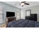 Bedroom featuring a flat screen TV, wood dresser and soft natural light at 2882 Manor Glen Ln, Suwanee, GA 30024