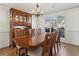 Formal dining room showcasing a wooden table set with chairs and a hutch, illuminated by a chandelier at 2882 Manor Glen Ln, Suwanee, GA 30024