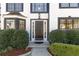 Elegant front entrance with a dark-stained door, sidelights, and manicured hedges creating an inviting curb appeal at 2882 Manor Glen Ln, Suwanee, GA 30024
