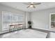 Bright, airy bedroom with a large window, ceiling fan, light gray walls, and hardwood floors at 3143 Stonegate Sw Dr, Atlanta, GA 30331