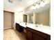 Bathroom featuring double sinks, a large mirror, modern lighting fixtures and tile flooring at 4125 Madison Bridge Dr, Suwanee, GA 30024