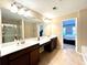 Bathroom featuring double sinks, a large mirror, modern lighting fixtures and tile flooring at 4125 Madison Bridge Dr, Suwanee, GA 30024